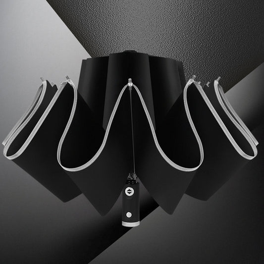 Black umbrella with a unique handle design on a dark background