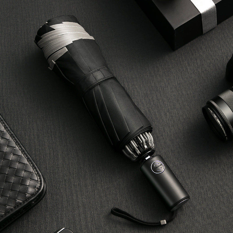 Black umbrella with silver accents on a dark textured surface