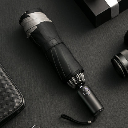 Black umbrella with silver accents on a dark textured surface