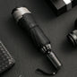 Black umbrella with silver accents on a dark textured surface