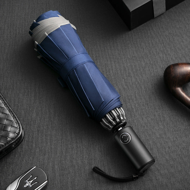 Blue umbrella with black handle on a dark textured surface
